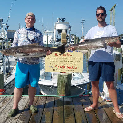Two anglers vacationing in Avon displaying their big Cobia on the inshore charter boat.