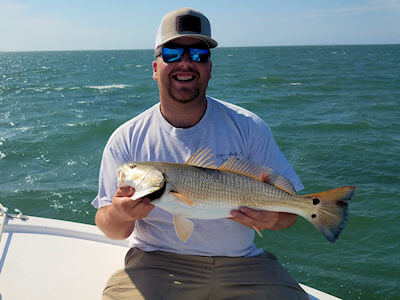 Angler holding a Redfish.