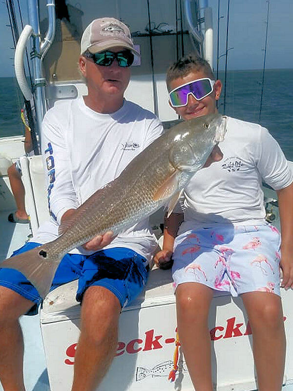 Captain Rick holds nice Red Drum caught by young angler on light tackle.