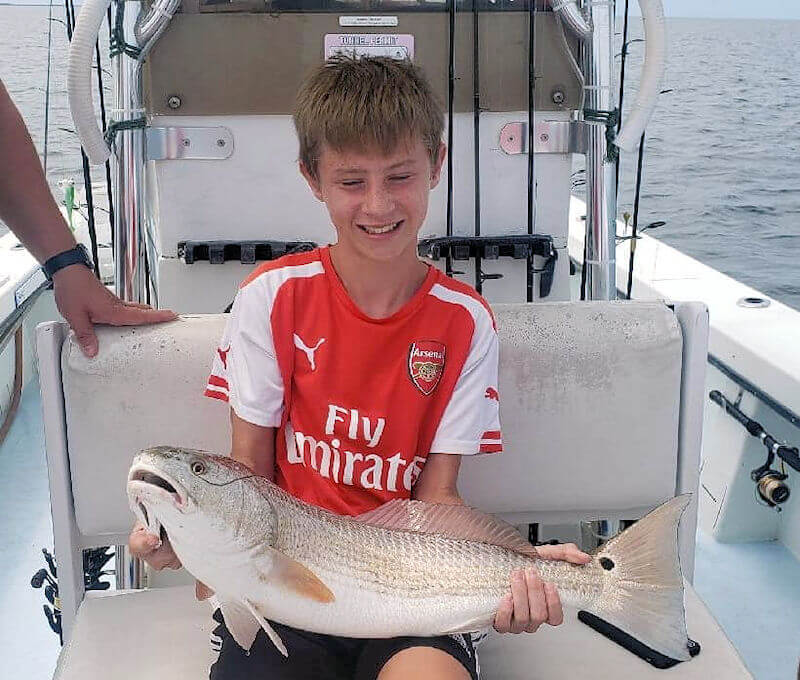 Young angler holds large Red Drum .