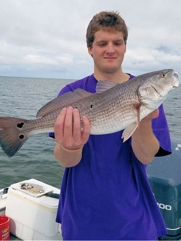 Angler holds up nice Hatteras Island Red Drum caught in Pamlico Sound.