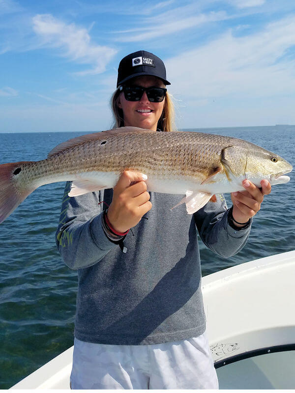 Lily Pierce holding a nice Red Drum she caught while taking a break from the Nags Head Surfing Tournament.
