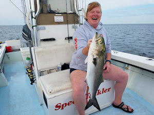 Lady angler holding large Pamlico Sound bluefish she just caught.